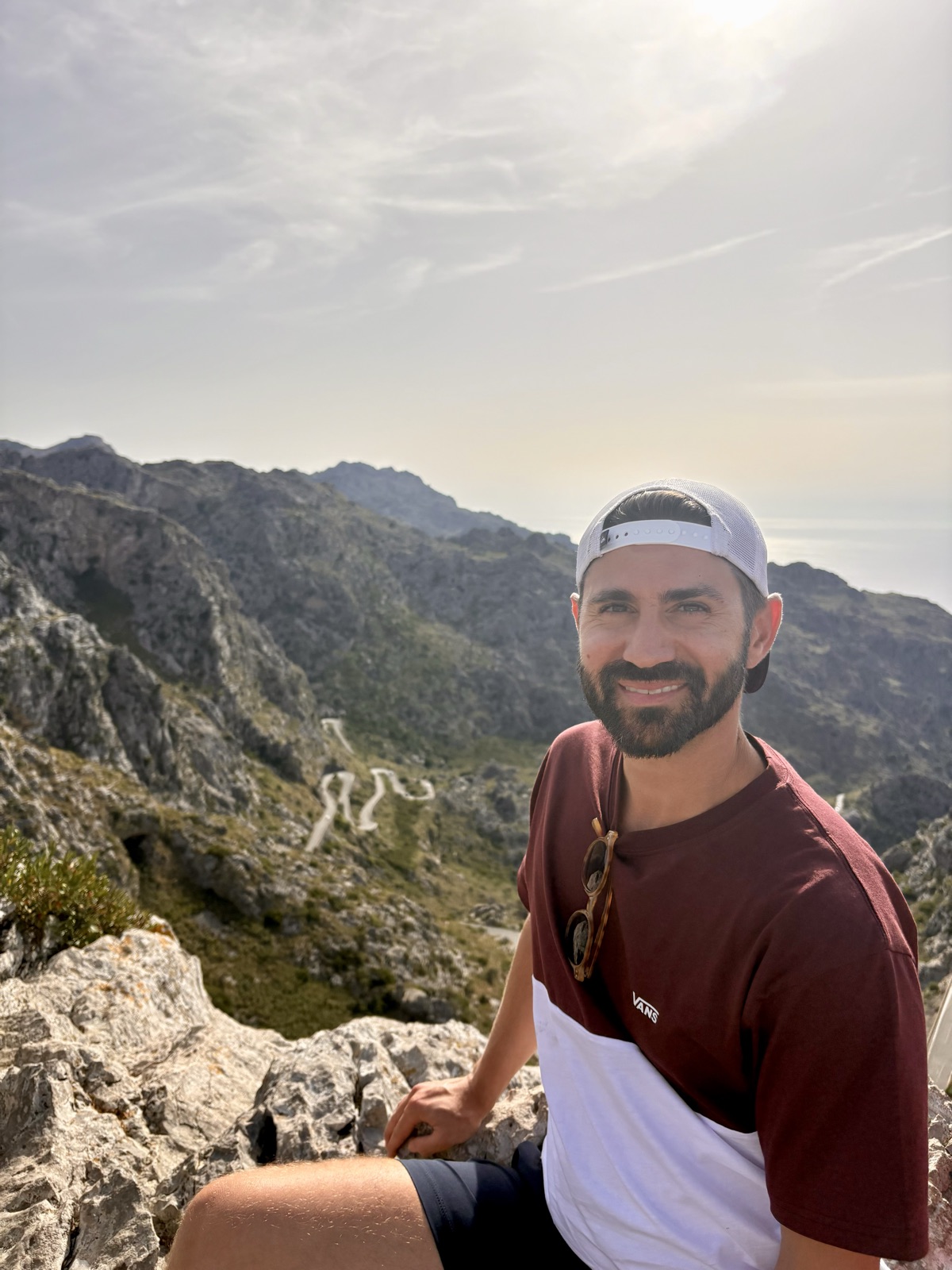 Hamza smiling at a mountain summit in Mallorca