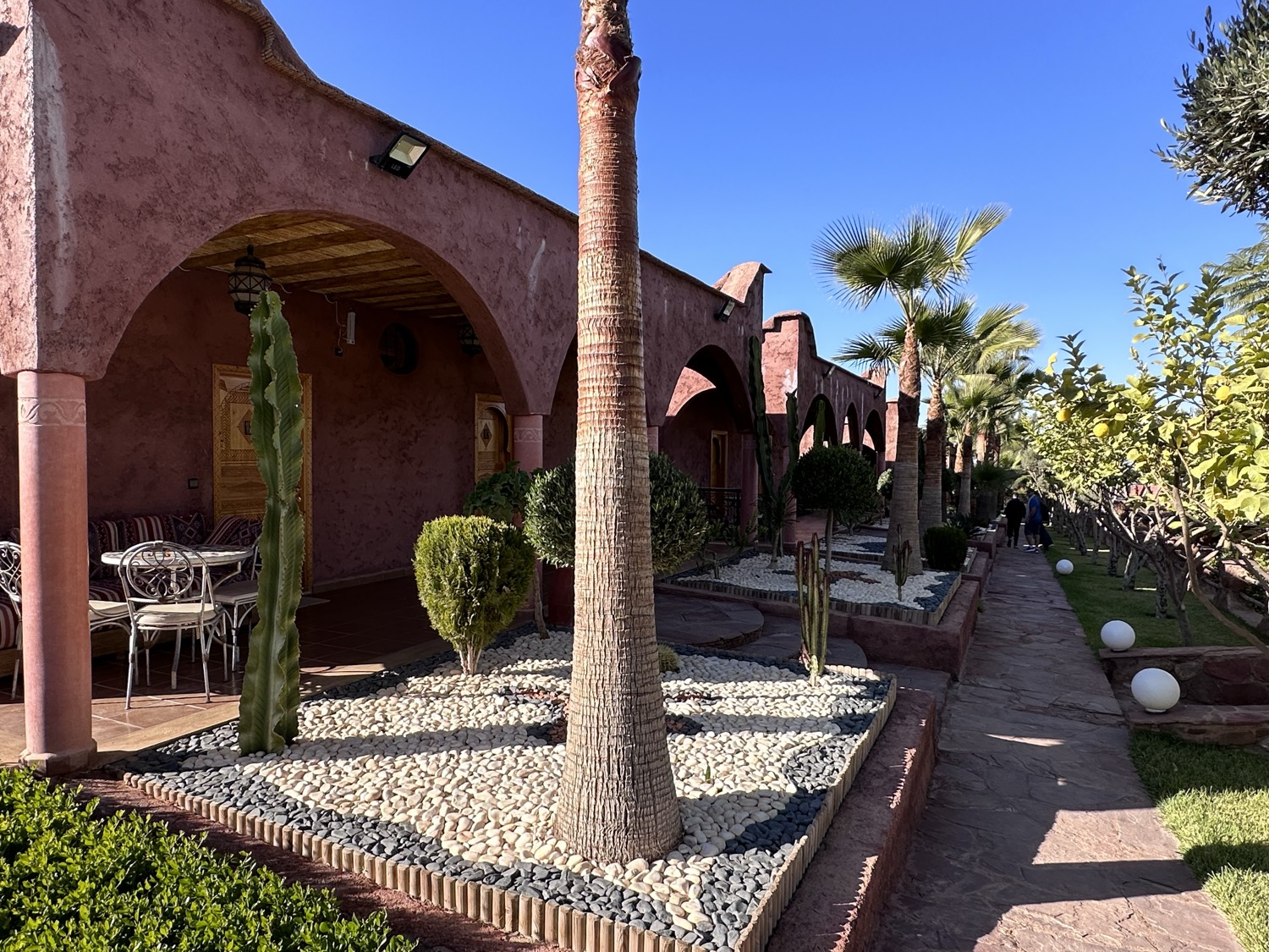 A Moroccan riad garden with palms and terracotta arches — the kind of place a tailored search uncovers